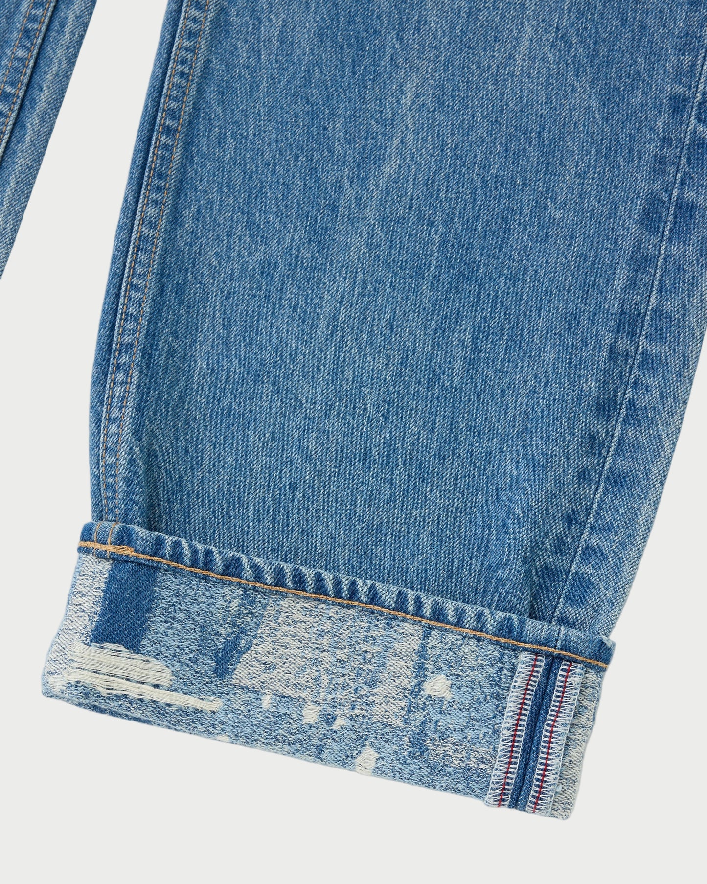 Close-up of blue denim jeans with a white background