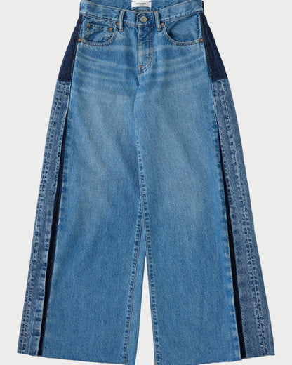 Blue jeans with black side panels on a white background