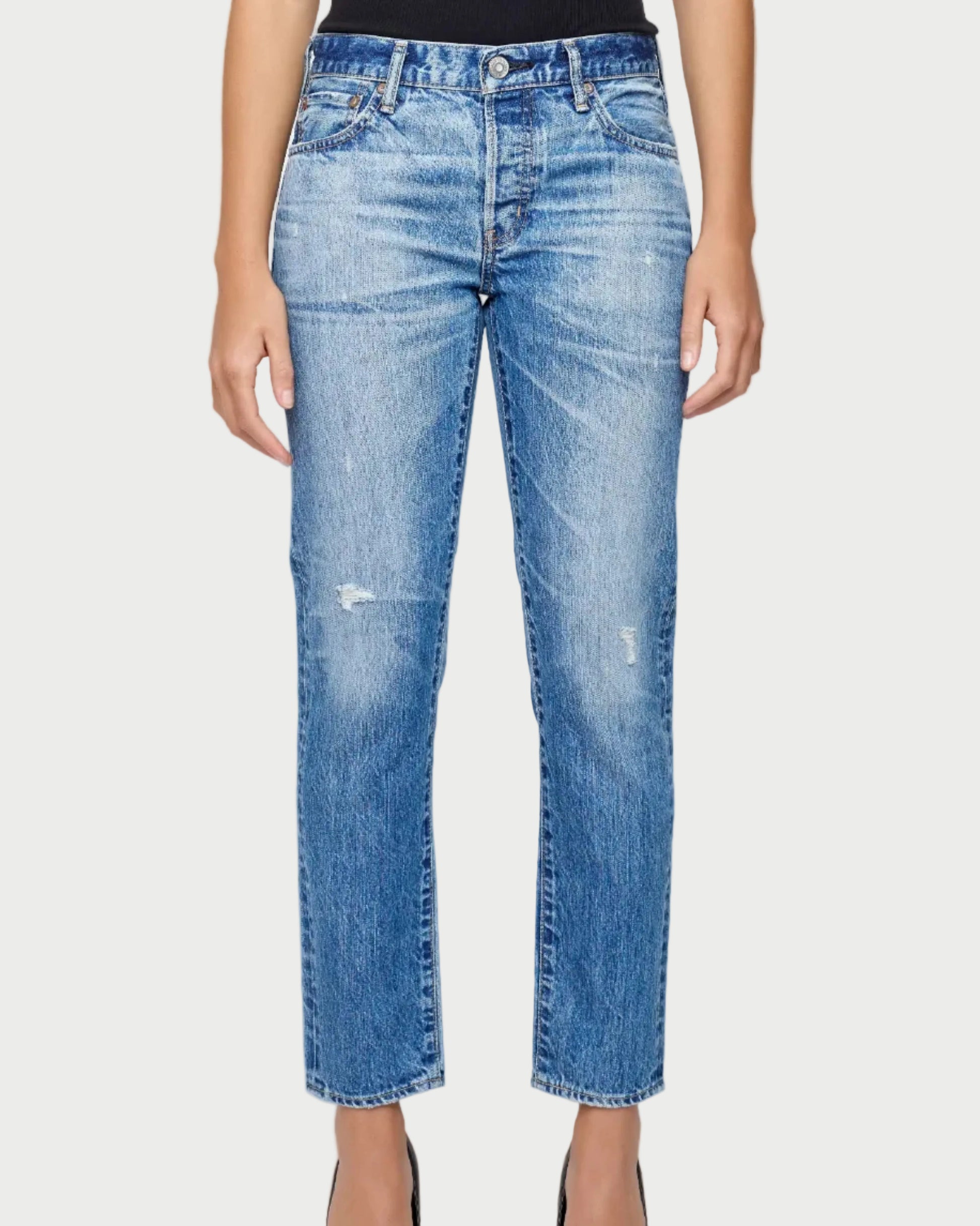 Person wearing light blue jeans on a white background