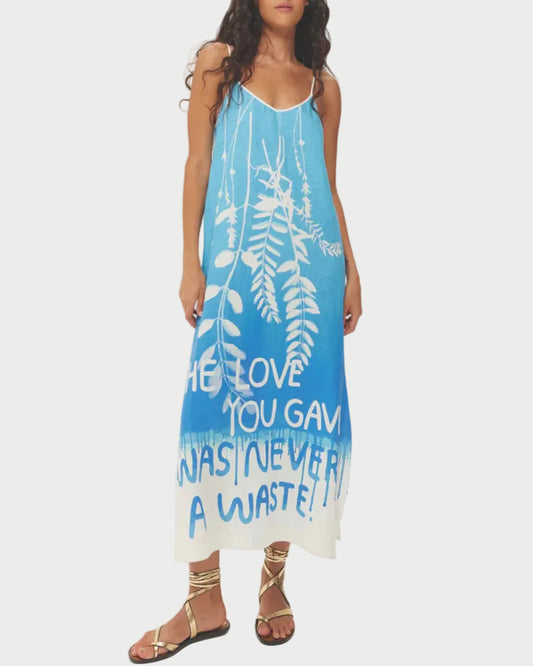 Woman wearing a blue dress with white text and patterns on a white background