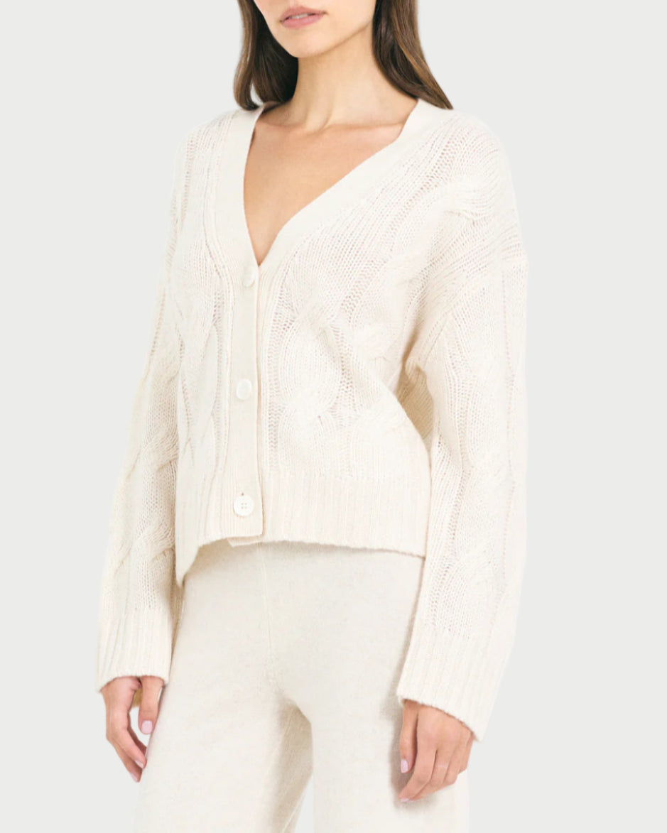Woman wearing a white ribbed sweater and pants on a white background