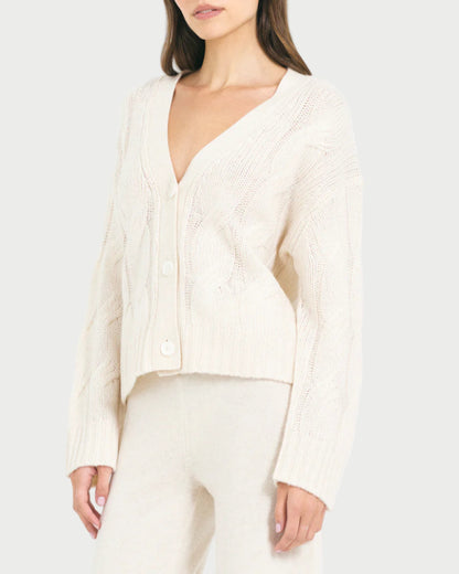 Woman wearing a white ribbed sweater and pants on a white background