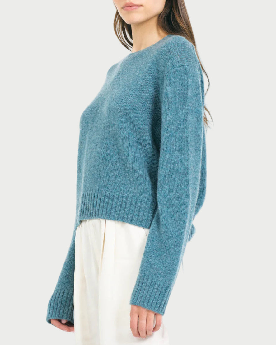 Woman wearing a blue sweater on a white background