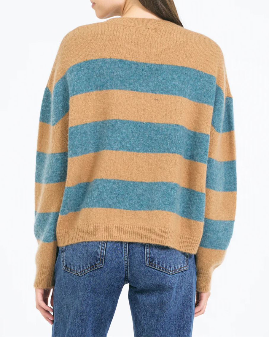 A person wears the One Grey Day Sophie Pullover—a relaxed fit, long-sleeve sweater with wide tan and teal stripes—paired with blue jeans, seen from the back against a plain white background.