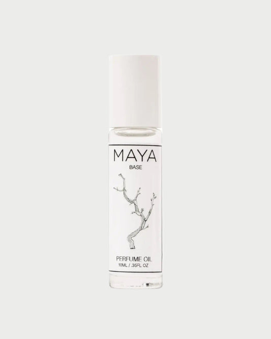 The MAYA Base 10ML by MAYA is a luxury roll-on scent in a clear glass bottle with a white cap and minimalist label featuring a delicate branch. This sustainable perfume oil offers 10ml (0.35 fl oz) of elegant fragrance.
