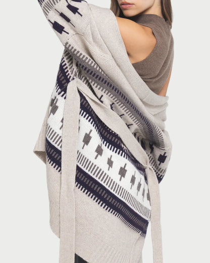 Woman wearing a patterned cardigan with a plain background