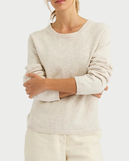 Woman wearing a beige sweater and pants on a white background