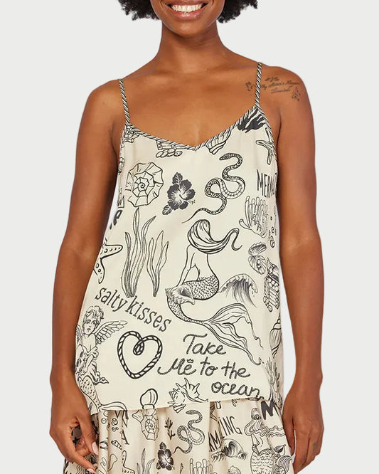 Woman wearing a dress with black graphics and text on a beach background