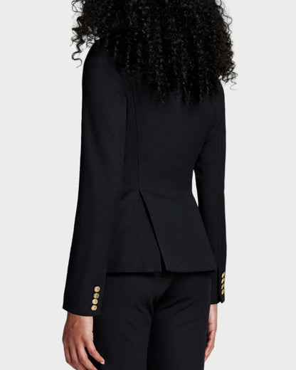 Person wearing a black suit with gold buttons on a white background