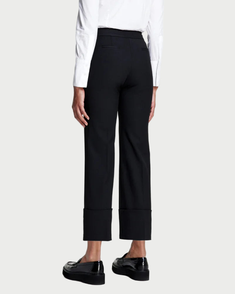 Person wearing a white blouse and black pants on a white background