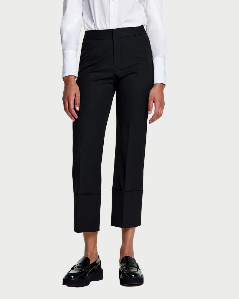 Woman wearing a white blouse and black pants on a white background