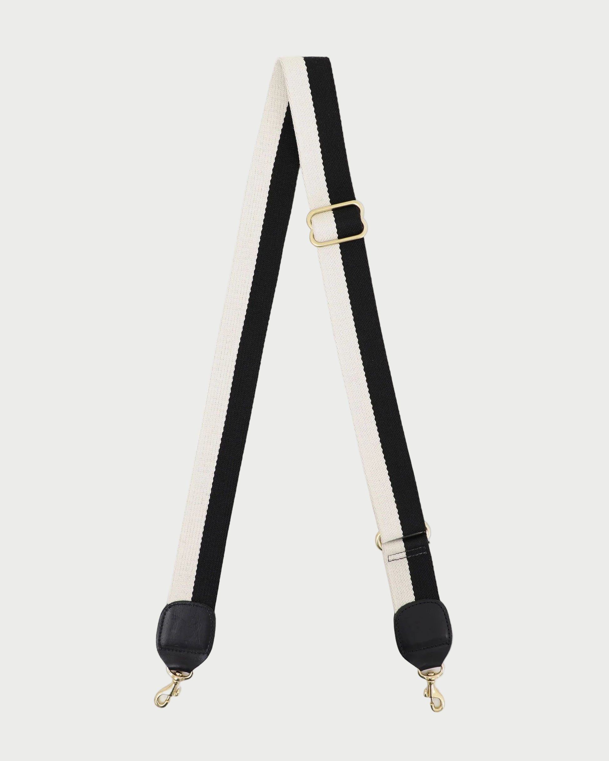 Black and white strap with gold hardware on a white background
