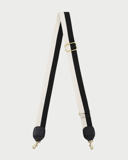 Black and white strap with gold hardware on a white background