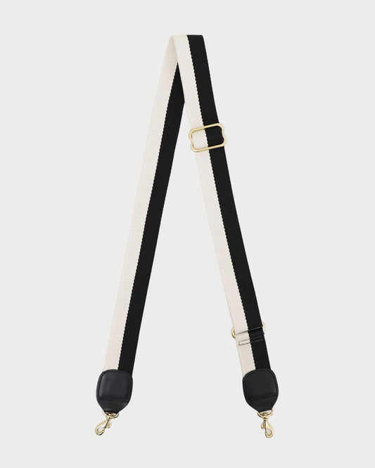 Black and white strap with gold hardware on a white background