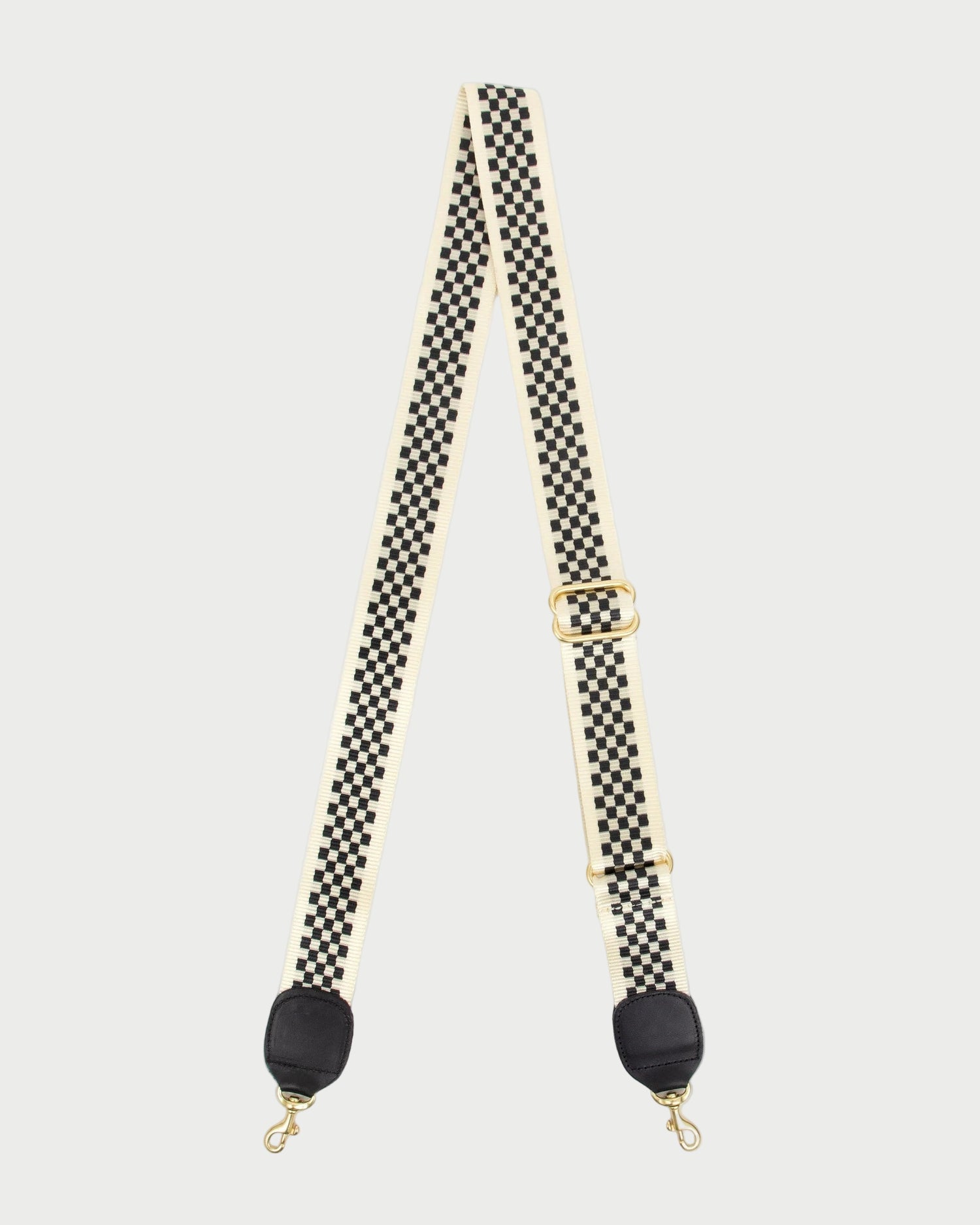 Checkered bag strap with black ends on a white background
