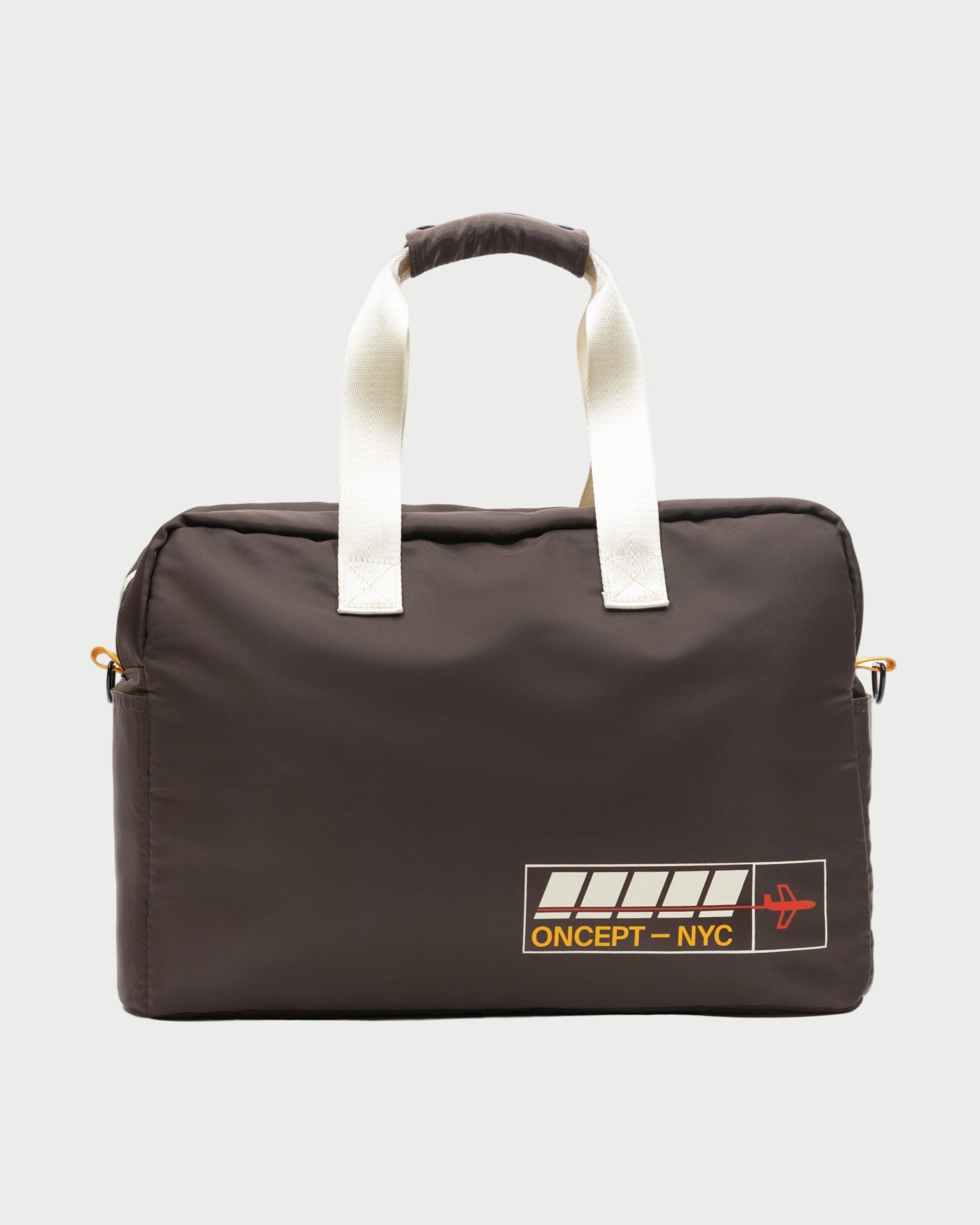 The Oncept Olympia Travel Bag is a dark brown duffel with white handles, a yellow "ONCEPT – NYC" logo, and a red airplane graphic on the lower corner, shown against a plain light backdrop.