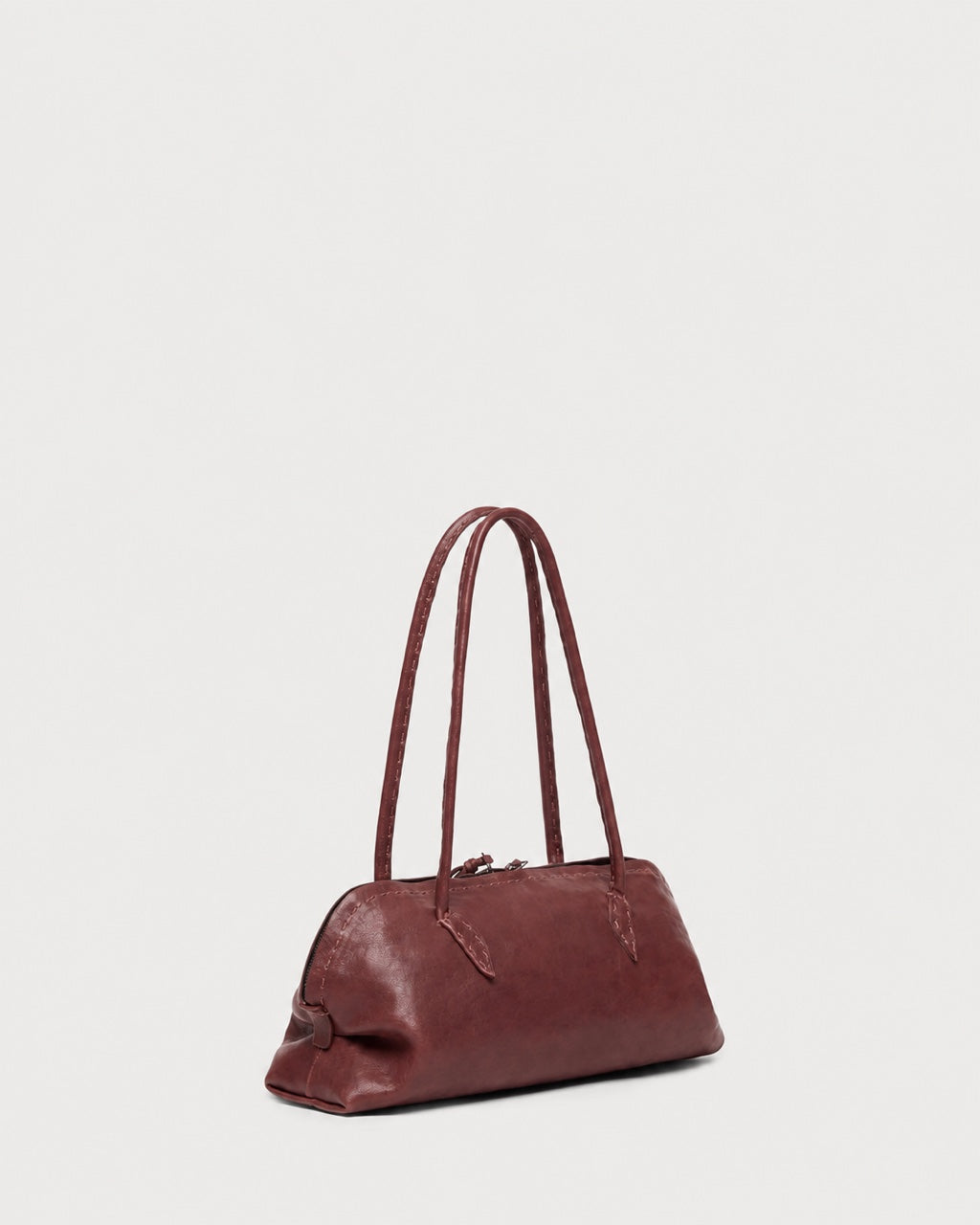 Maroon Henry Beguelin Bolla Bassa Bag featuring Italian craftsmanship, designed with two slender shoulder straps and a zippered top closure.