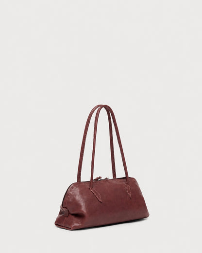 Maroon Henry Beguelin Bolla Bassa Bag featuring Italian craftsmanship, designed with two slender shoulder straps and a zippered top closure.