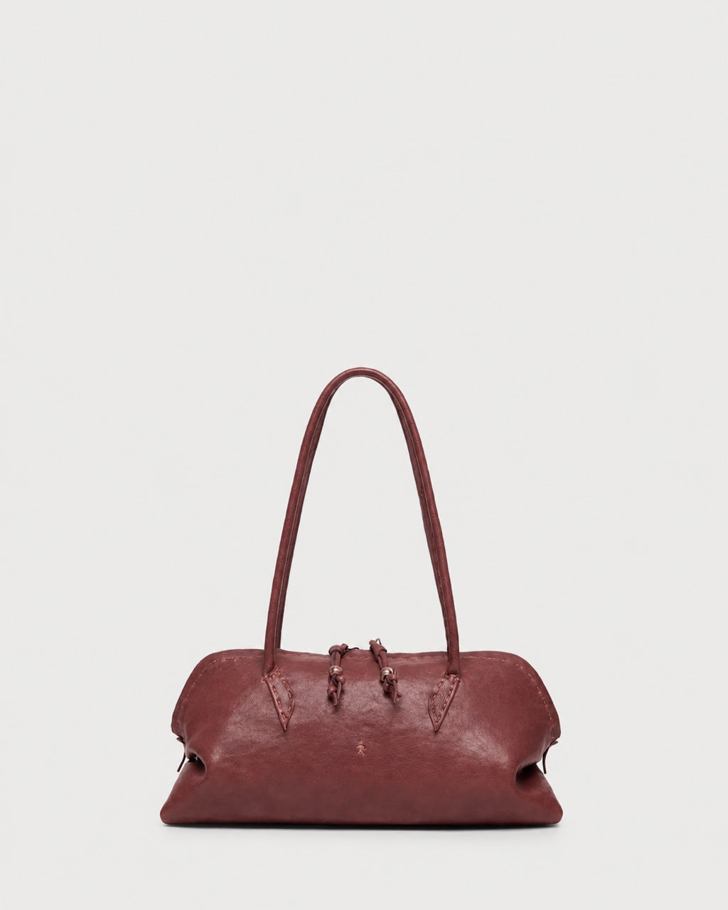 A slouchy, rounded maroon Henry Beguelin Bolla Bassa Bag with a top handle, showcasing fine Italian craftsmanship.