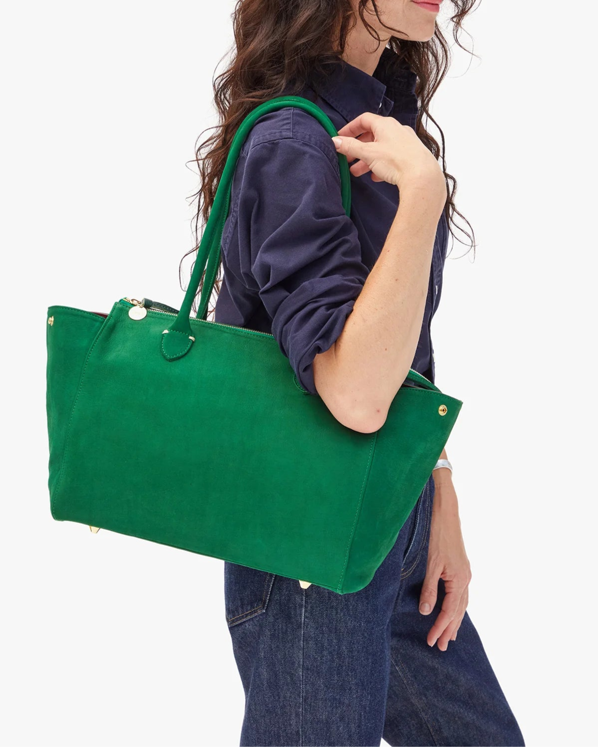 Woman holding a green tote bag against a white background