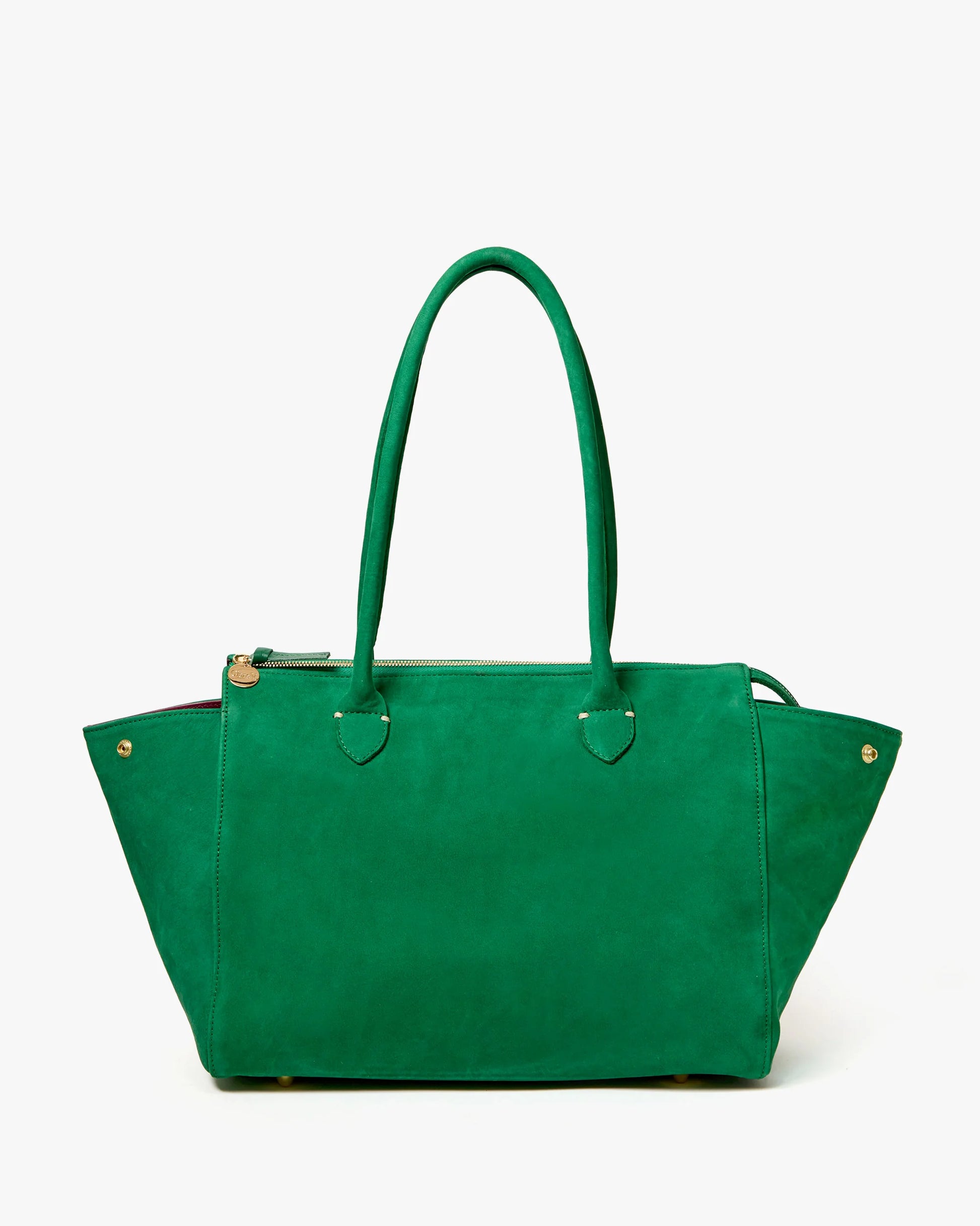 The CLARE V. Beatrice Tote Bag is a large, structured emerald green suede tote with double handles, gold-tone accents, and a top zipper, shown against a white background.