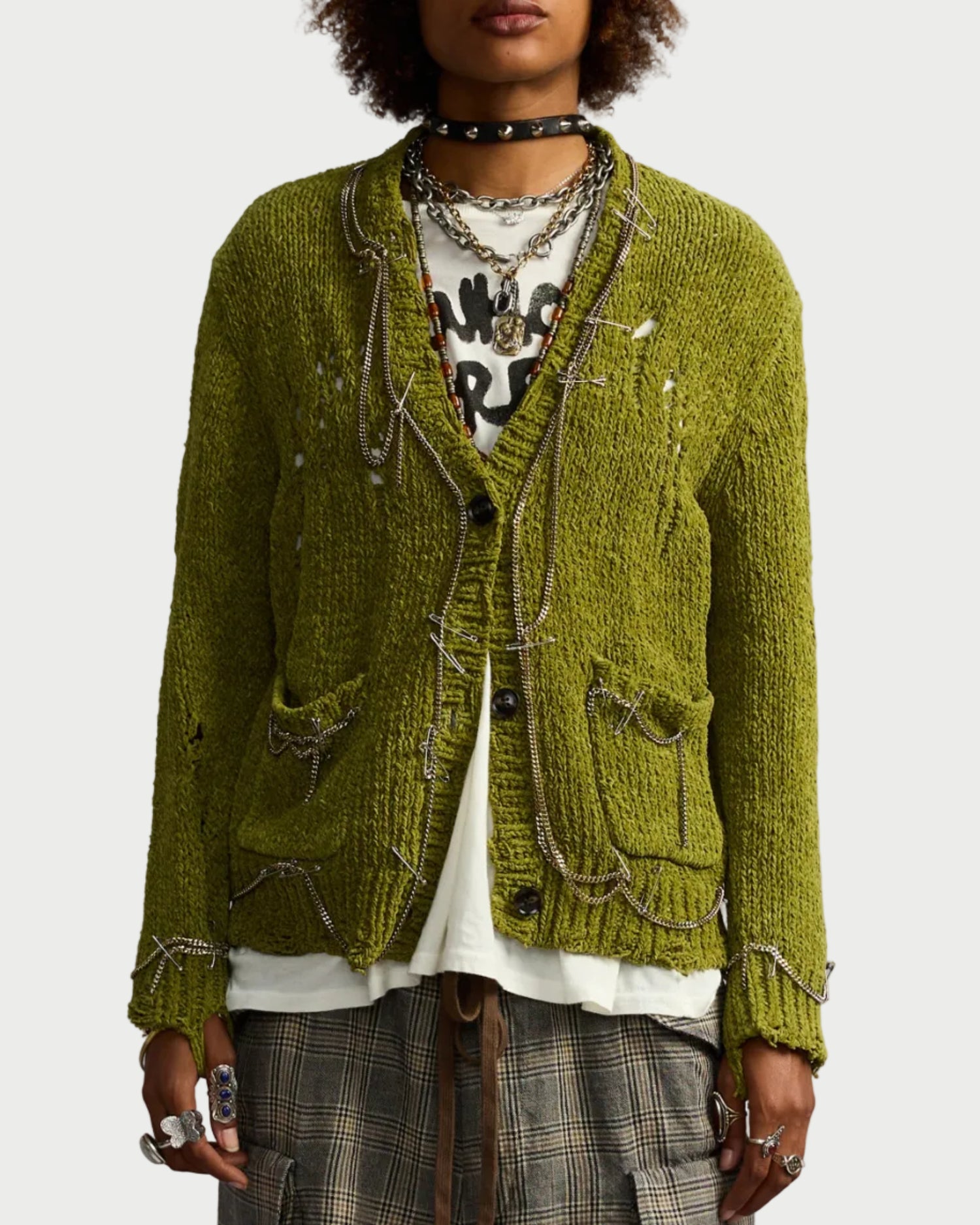 Person wearing a green textured jacket with a plain background