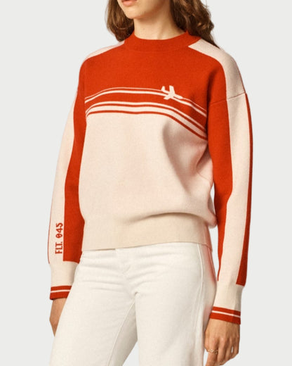 Person wearing a red and white striped sweater with a neutral background