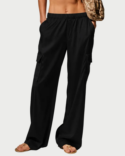 Woman wearing a white halter top and black pants against a gray background