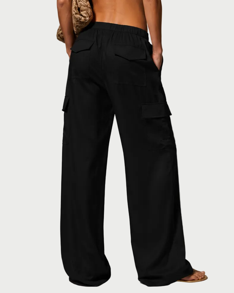 Person wearing a white top and black pants against a gray background