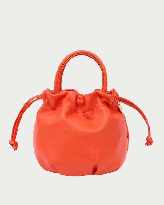 A small bright orange leather drawstring bucket bag with a top handle, photographed on a clean white background.