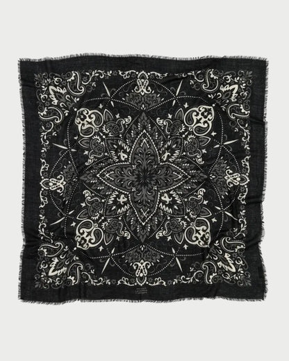 The Maison Lecomte Flament Bandana Scarf Black features intricate white paisley and floral patterns with a central star-like motif and frayed edges—a signature accessory from Maison Lecomte Flament.