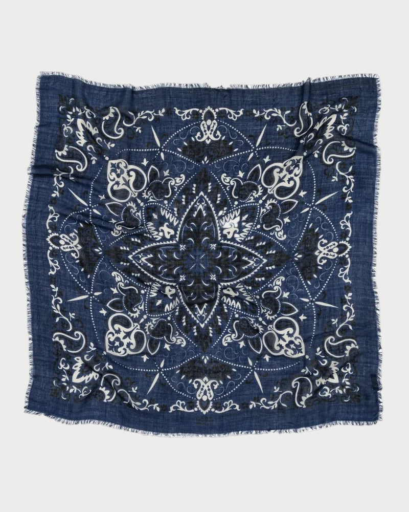 The Bandana Scarf Navy by Maison Lecomte Flament is a square cotton voile scarf in navy, featuring white and black floral and paisley patterns, a large central star design, and frayed edges.
