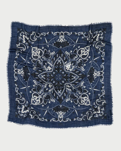 The Bandana Scarf Navy by Maison Lecomte Flament is a square cotton voile scarf in navy, featuring white and black floral and paisley patterns, a large central star design, and frayed edges.