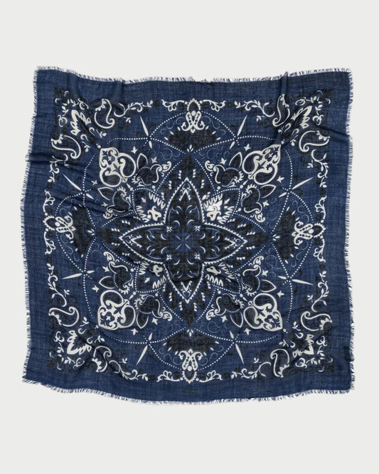 The Bandana Scarf Navy by Maison Lecomte Flament is a square cotton voile scarf in navy, featuring white and black floral and paisley patterns, a large central star design, and frayed edges.