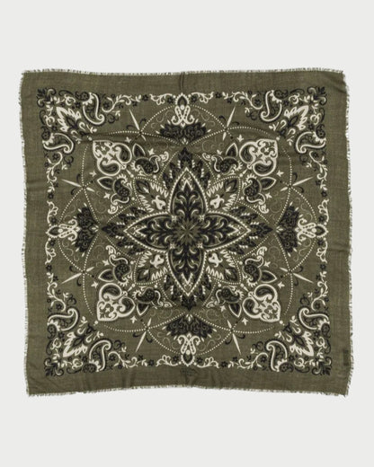 The Bandana Scarf Khaki by Maison Lecomte Flament is a square cotton voile bandana with a fringed edge, featuring a symmetrical paisley and floral design in black, white, and olive green.