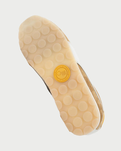 The image shows the sole of the Oncept Essex Sneaker - Ginger by Oncept, featuring a translucent rubber bottom with large circular grips and a yellow logo at the center, highlighting its sustainable design.