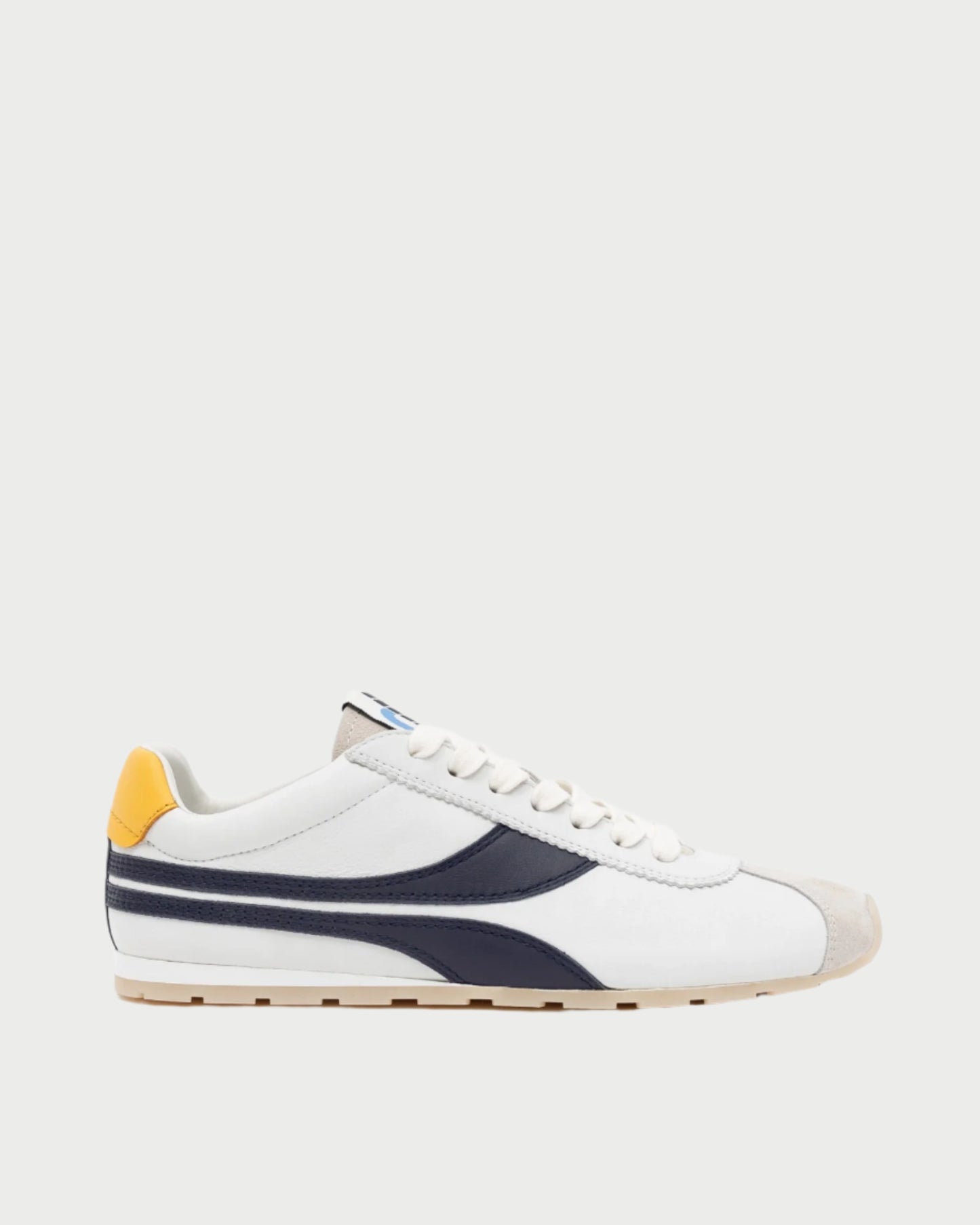 The Essex Sneaker by Oncept is a versatile white shoe with navy, gray detailing, white laces, a mustard heel accent, and beige suede toe cap. It features a white sole with light brown bottom and is pictured against a plain light gray background.