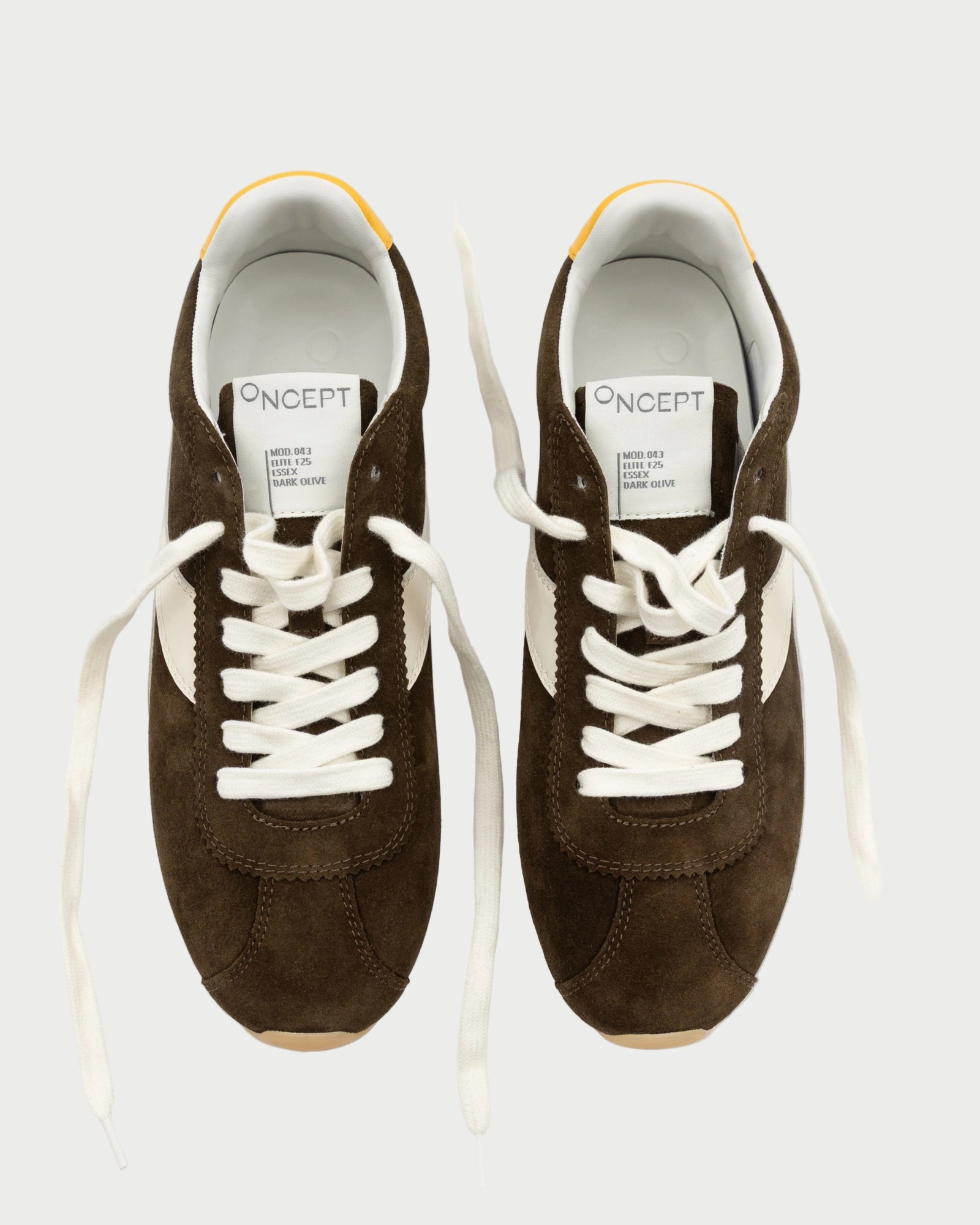 Pair of brown sneakers with white laces on a white background
