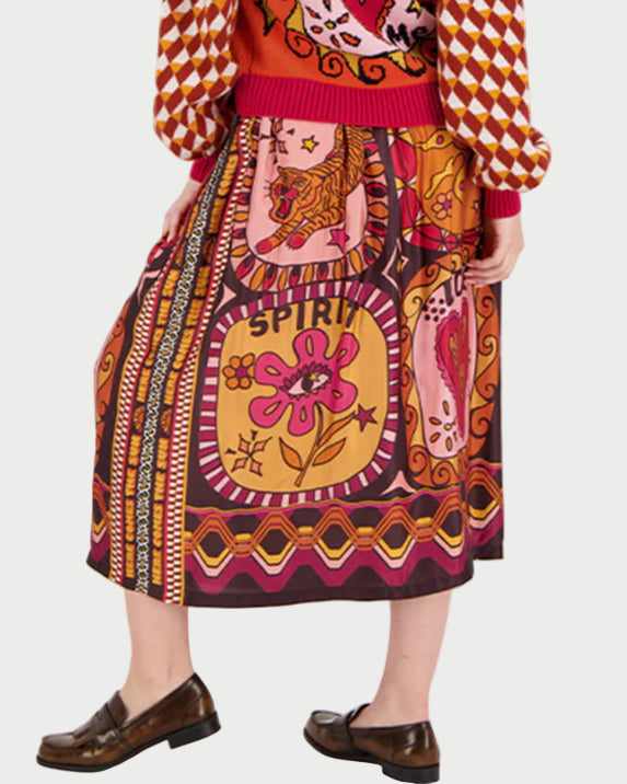 Woman wearing a colorful patterned dress with a white background