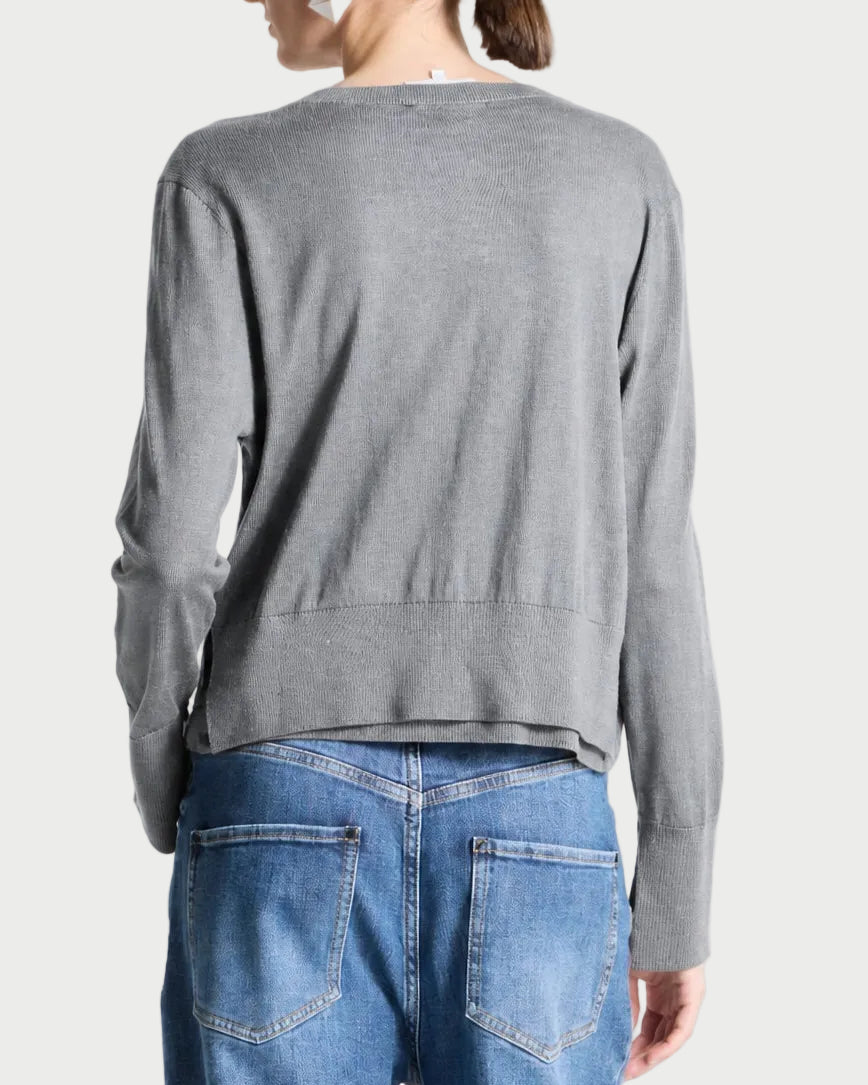 A model shown from the back wearing a gray long-sleeve knit sweater and blue jeans against a light gray studio background.