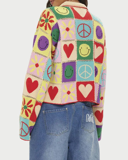 Person wearing a colorful patchwork sweater with various symbols on a white background