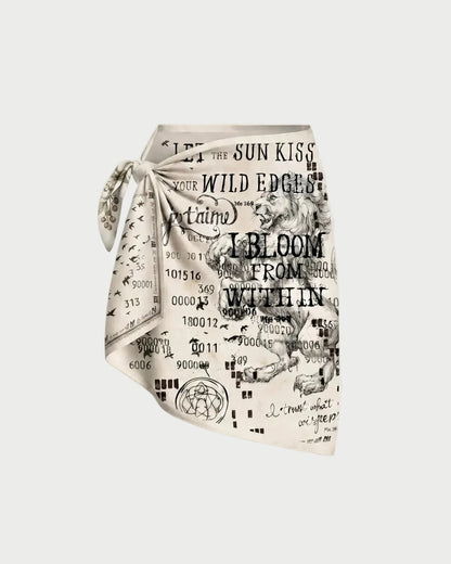 A square scarf with a black and white graphic print featuring text, numbers, and vintage-style illustrations, tied in a knot on a light beige background.