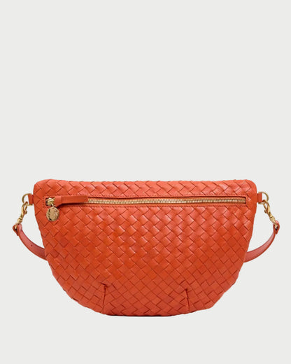 The CLARE V. Clare V. Woven Grande Fanny is an orange woven leather crossbody belt bag with gold hardware, a front zipper pocket, and a detachable strap, shown on a plain white background.