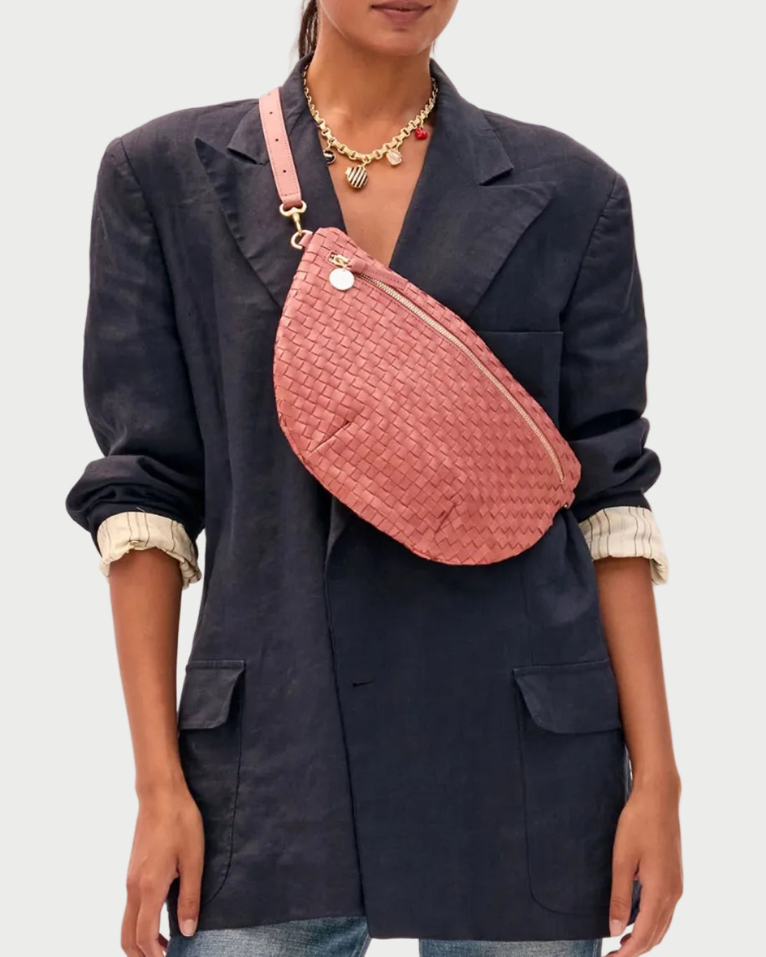 Woman wearing a pink quilted bag over her shoulder against a white background