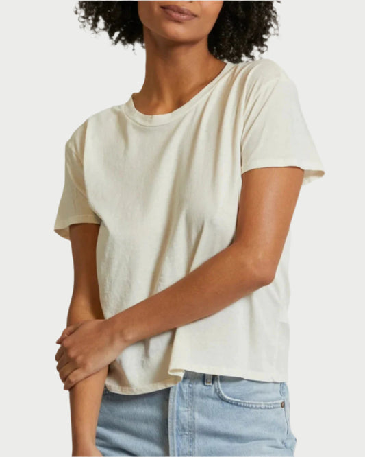 A person wearing a Bright Ivory Harley T-Shirt from perfectwhitetee and mid-rise denim stands with arms crossed, set against a solid off-white background.
