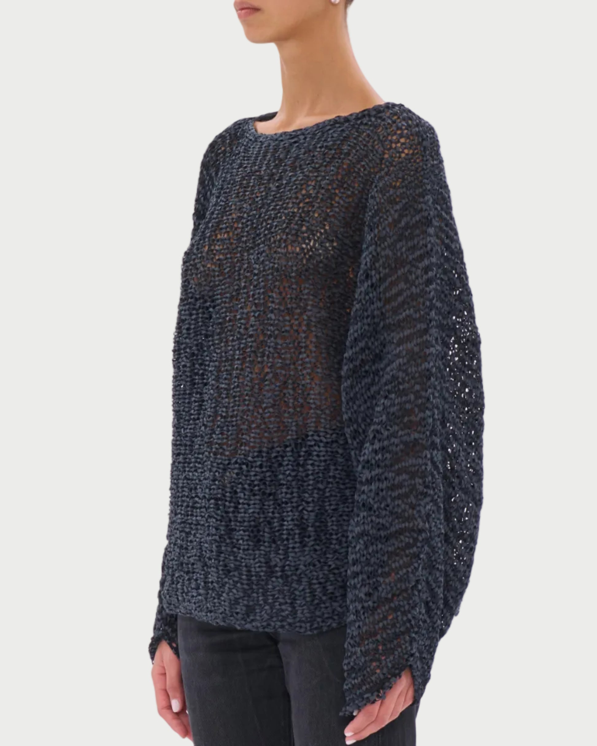 Woman wearing a dark textured sweater and sunglasses on a white background