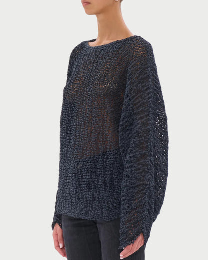 Woman wearing a dark textured sweater and sunglasses on a white background