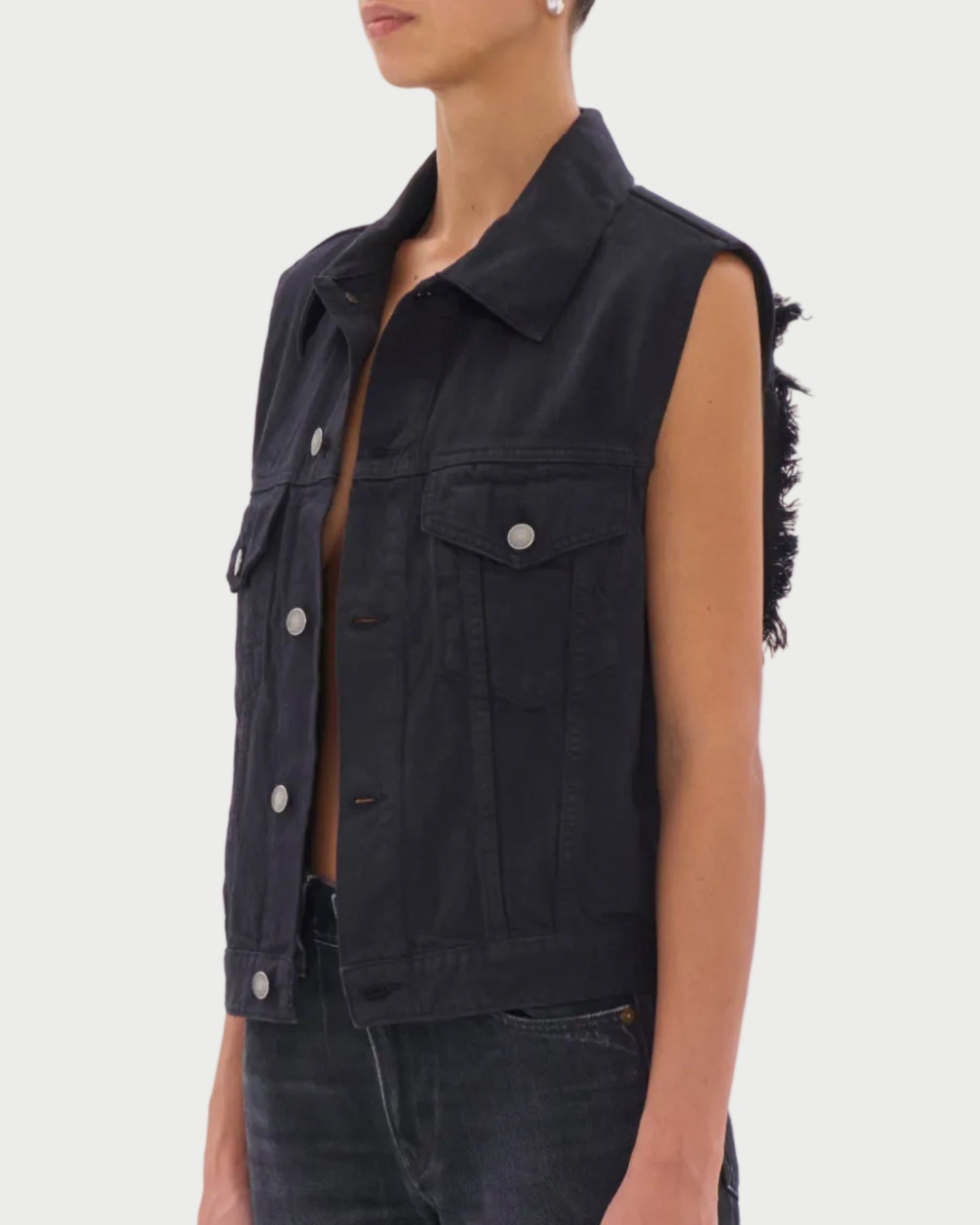 Woman wearing a black sleeveless denim vest and sunglasses on a white background