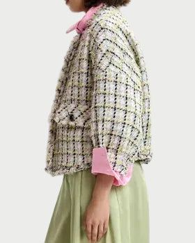 Woman wearing a patterned jacket and green skirt on a white background