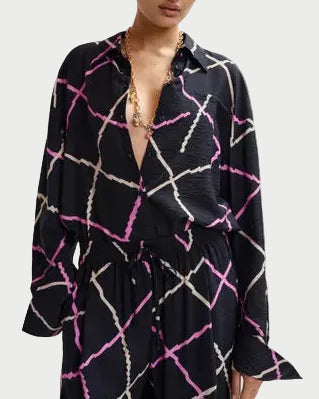 Woman wearing a black patterned outfit on a white background